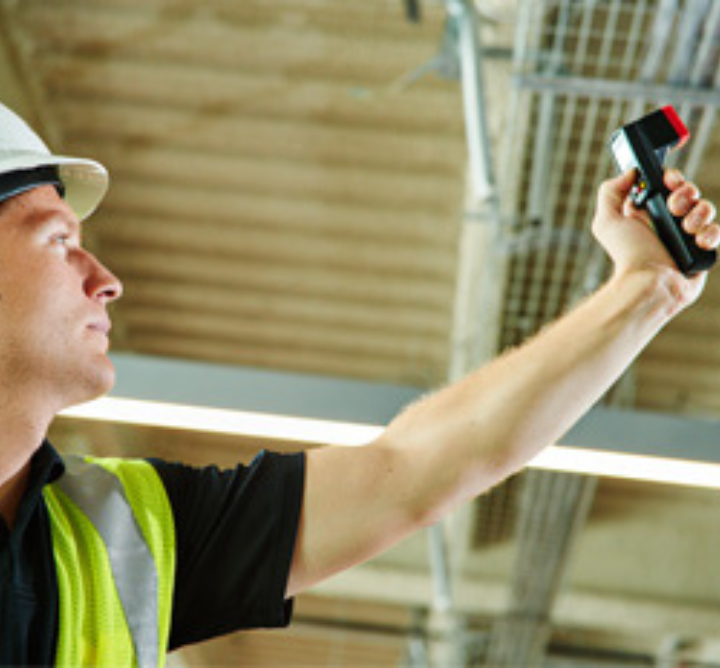 A worker in safety gear checking equipment.